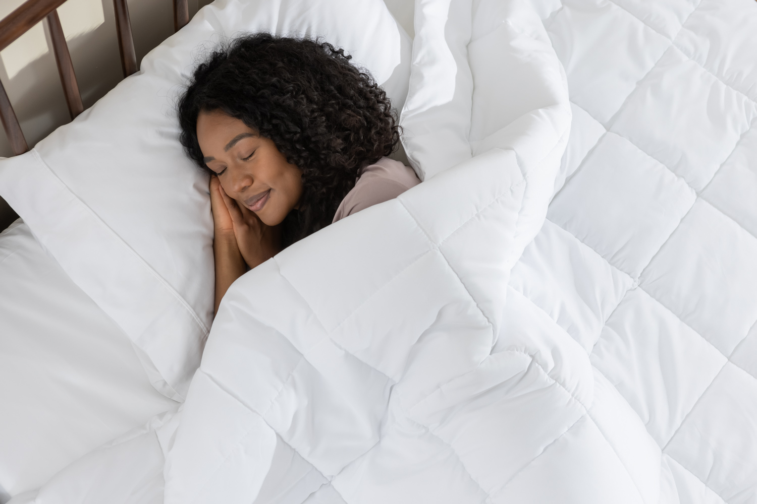  Une femme dort paisiblement sous sa couette en duvet synthétique 